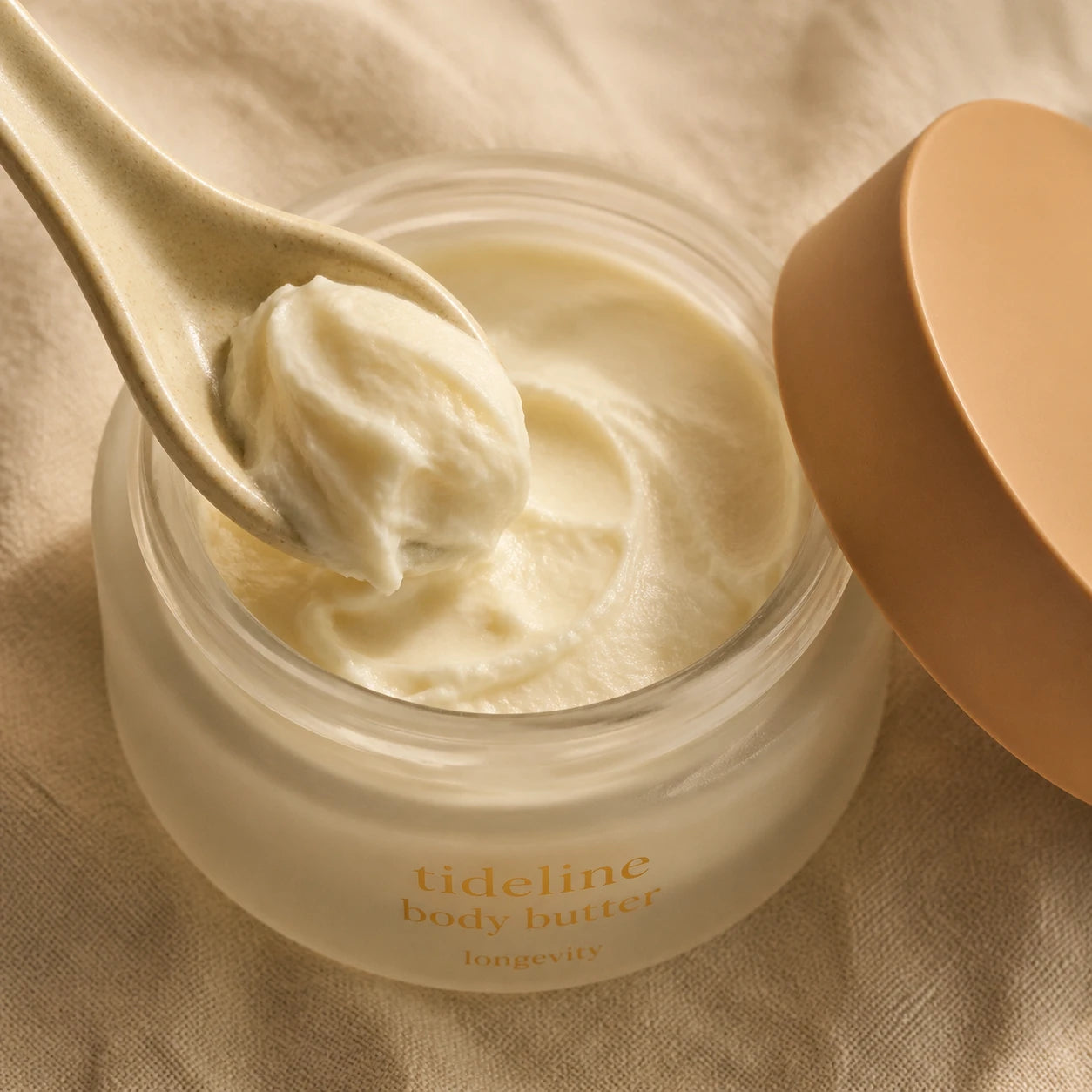 Close texture of a rich body butter, scooped and catching warm light